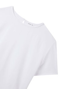 T-shirt bianco a maniche corte con scollatura rotonda e una sottile texture. Presenta un piccolo'apertura a forma di chiave sul retro. Etichetta del marchio visibile.