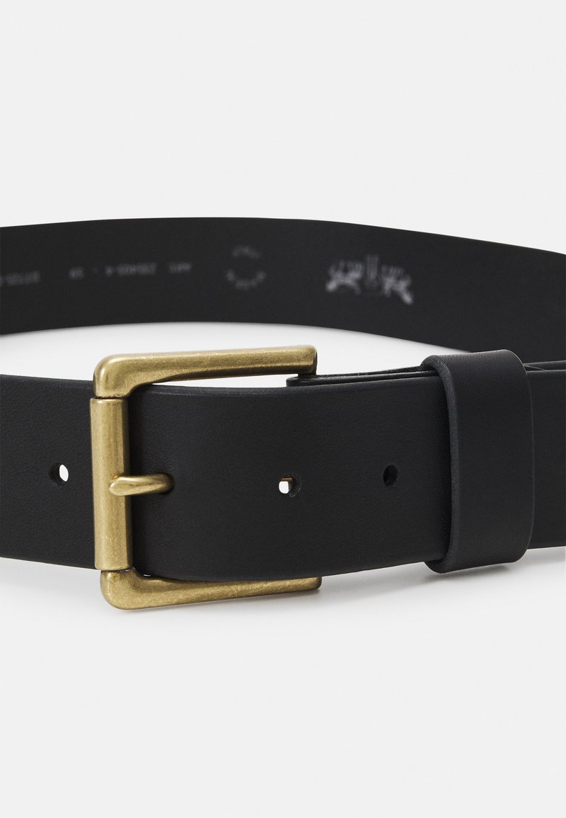 Sorte læderbælte med en guldmetal spænde, glat tekstur og flere justeringshuller langs remmen for tilpasning.