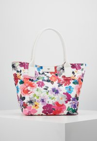 Plátěná taška s vícetranným květinovým vzorem v dominantních odstínech růžové, fialové a bílé, doplněná bílými držadly.
