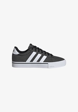 Black and white Adidas sneaker with three white stripes, black laces, padded collar, and thick white sole with textured design.