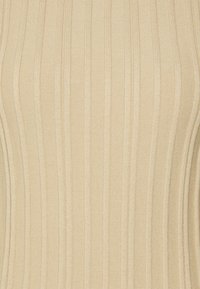 Tejido ribeteado beige con rayas verticales, que presenta una textura suave y un diseño ajustado. Sin hardware visible ni patrones.