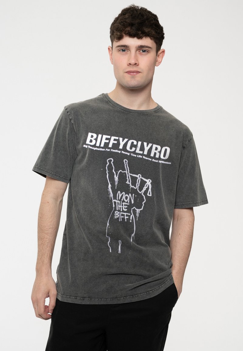 Gray cotton t-shirt with a relaxed fit, featuring white text and graphic design of a figure with bagpipes. Short sleeves and crew neck.