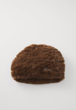 Brūna mākslīgā kažokāda ar mazu metāla Guess logo sānos, attēlota uz baltas fona.