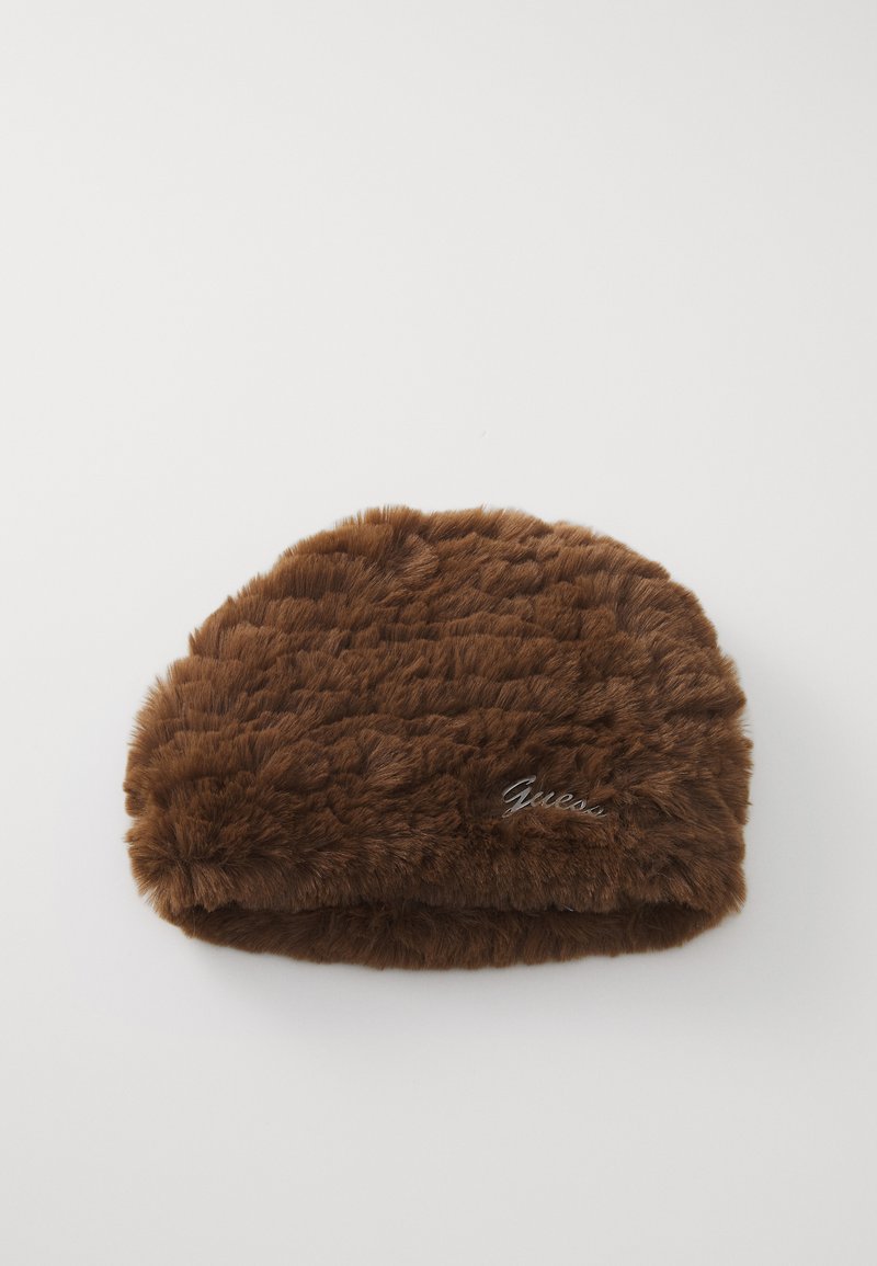 Brūna mākslīgā kažokāda ar mazu metāla Guess logo sānos, attēlota uz baltas fona.