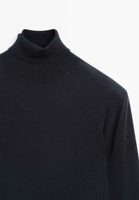 Svart polo tröja gjord av mjukt stickat material. Har en hög ribbad krage och en figurnära design, slät textur, med rena sömmar.