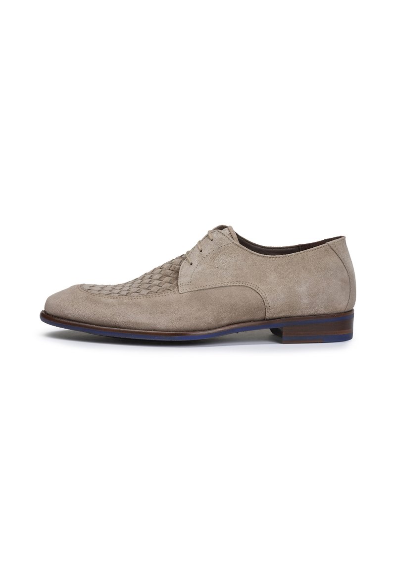 Chaussure beige en daim à lacets avec une texture tissée sur le bout, silhouette arrondie et une semelle en cuir marron foncé avec un accent bleu subtil.