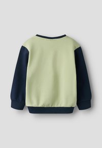 Grønn og marineblå genser med lange ermer, ribbestrikkede mansjetter og kant. Mykt stoff med avslappet passform og minimalistiske sømdetaljer.