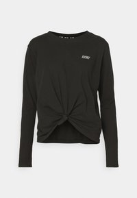 Svart långärmad skjorta med knuten frontdetalj, har rund halsringning och liten vit "DKNY"-logotyp på bröstet. Mjuk tygtextur.