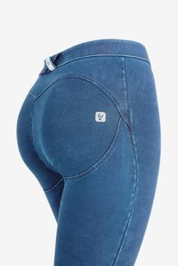 Syvänsiniset denimpleggingsit, joissa on sileä tekstuuri, kaareva muotoilu ja pieni logo takataskussa.