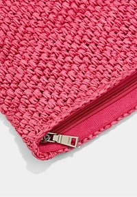 Bustina rosa intrecciata con tessuto strutturato e chiusura con cerniera; presenta una fodera interna liscia e robusti componenti metallici.