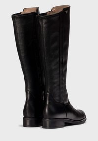 Bottes en cuir noir jusqu'aux genoux avec un design élégant, une texture lisse et un détail de couture subtil. Fermeture à glissière latérale et petit talon carré.