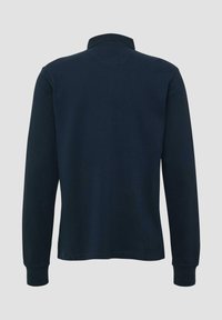 Marineblauwe lange mouwen poloshirt met geribde manchetten en een kraag, weergegeven vanaf de achterkant op een effen grijze achtergrond.