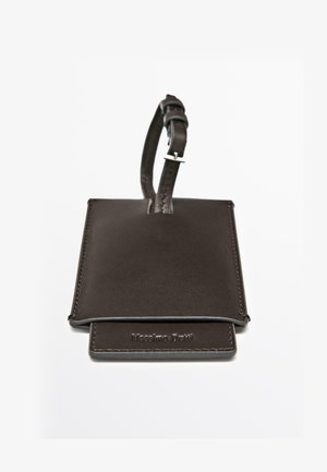 Bruine leren bagagelabel met een gladde textuur, gestikte randen en een verstelbare riem met een metalen gesp.