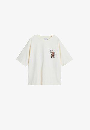 Crème-kleurige katoenen T-shirt met korte mouwen, voorzien van bedrukte zwarte en rode tekst en graphics op het linkerborstgebied.