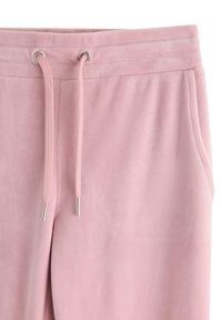 Bløde lyserøde sweatpants med justerbar snoretræk i taljen og sidelommer, lavet af blødt stof.