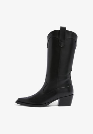 Botas de vaquero de cuero negro con punta afilada, detalles de costura western y un tacón bloque de altura media. Cuenta con una lengüeta en la parte superior para facilidad de uso.