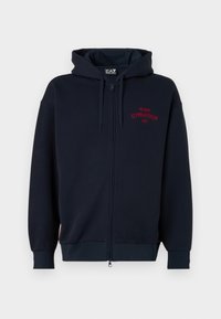 Marinblå zip-up hoodie med en rymlig huva, elastiska ärmslut och midja. Har röd text "MILANO GYMNASIUM EA7" på bröstet. Mjuk tygkvalitet.