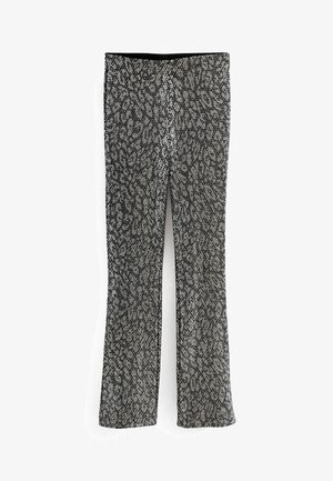 Czarno-białe spodnie w panterkę o dopasowanym kroju z lekkim rozszerzeniem na dole, ułożone płasko na białym tle.
