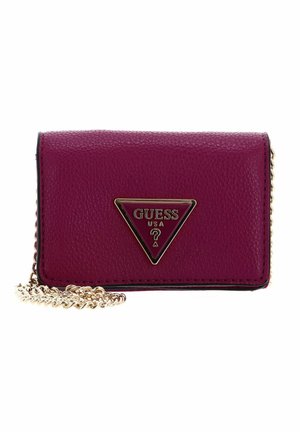 Portefeuille en cuir fuchsia avec une bandoulière chaîne dorée, plaque logo métallique triangulaire, extérieur texturé et accents noirs autour des bords.