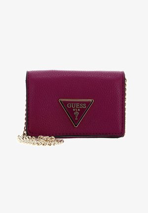 Portefeuille en cuir fuchsia avec une bandoulière chaîne dorée, plaque logo métallique triangulaire, extérieur texturé et accents noirs autour des bords.