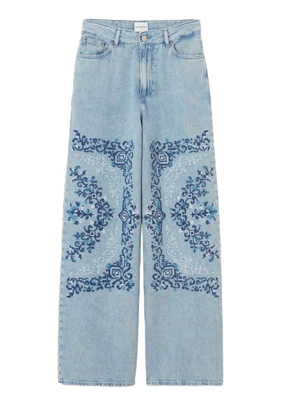 Jeans azzurri chiari a gamba larga con ricami geometrici intricati in blu scuro e chiaro su cosce e ginocchia anteriori, stile classico a cinque tasche.