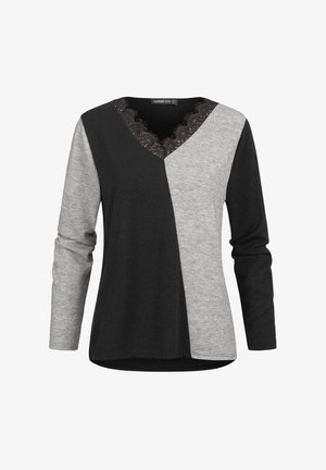 Haut femme à manches longues avec des blocs de couleur noir et gris asymétriques et col en V bordé de dentelle.