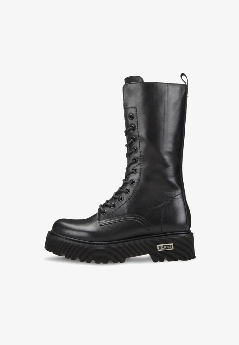 Czarne skórzane buty wojskowe z wysoką cholewką, okrągłym noskiem, płaską podeszwą i bocznym zamkiem. Posiadają sznurowane zapięcie oraz metalowe ozdoby.