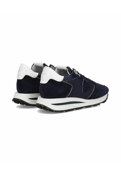 Baskets en nubuck bleu marine avec des accents en cuir blanc, design à lacets, surface texturée et semelle en caoutchouc noir présentant des détails courbés.