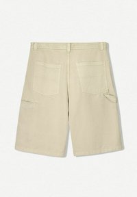 Shorts bej de lungime medie, confecționați din bumbac, cu două buzunare la spate și un buzunar lateral, având o textură netedă și un design cu picioare drepte.