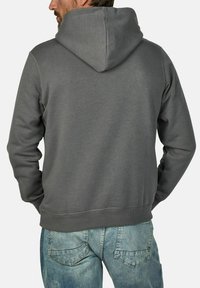 Gray hooded sweatshirt with a smooth texture, featuring a kangaroo pocket and ribbed cuffs, paired with light blue denim jeans.