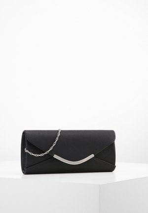 Pochette rectangulaire noire avec un fermoir incurvé en argent et une fine chaîne argentée reposant sur une surface blanche.