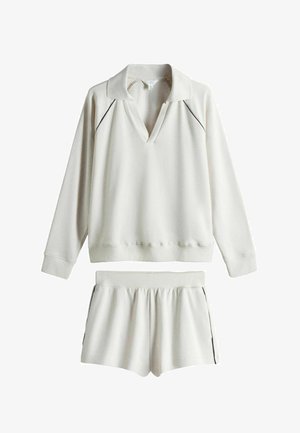 Cremefarbener Pullover mit langen Ärmeln und Kragen sowie passende Shorts mit elastischem Bund, beide mit dünnem schwarzem Paspel an den Kanten.