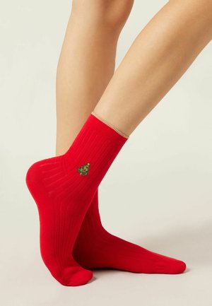 Røde ribbede bomuldsstrømper med en guldkant ved manchetten og et lille broderet julet trædesign på siden.