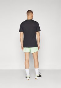 Nike Performance STRIDE - Sports shorts - vapor green/dark stucco/reflective silver