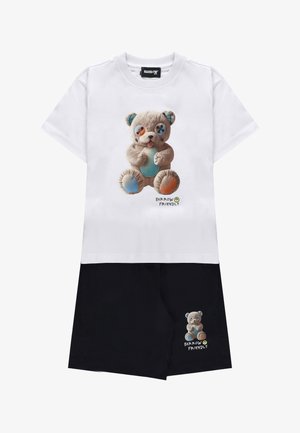 Completo con maglietta bianca e pantaloncini neri, con orsetto dagli occhi a bottone e toppe blu e arancioni, etichettato "Barrow Friendly."