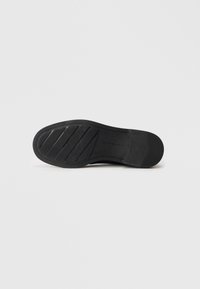 Black shoe sole with textured rubber surface, featuring horizontal and vertical grooves for grip. Marked size 37.