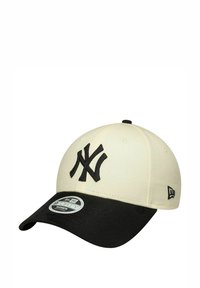 Cappello nero e crema con logo ricamato dei New York Yankees, una corona strutturata e una visiera curvata con una delicata texture.