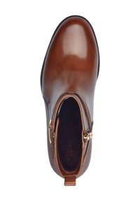 Bottine en cuir marron avec une finition lisse, fermeture éclair sur le côté et une boucle de tirage, présentant un design à bout arrondi.