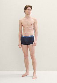 Boxers noirs bleus foncés avec une ceinture douce arborant le nom de la marque "TOM TAILOR." Fabriqués en tissu lisse, design ajusté et longueur mi-cuisse.