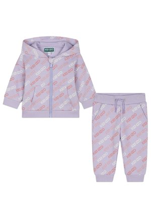 Survêtement lilas comprenant un hoodie zippé et un pantalon assorti, tous deux ornés de logos "KENZO" répétés en rouge et blanc. Tissu en mélange de coton.