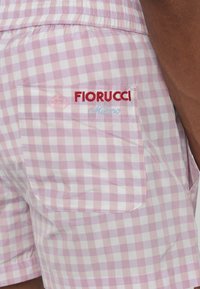 Roze karirane šortse sa elastičnom trakom u struku. Sadrži stražnji džep sa izvezenim tekstom "Fiorucci Milano" u crvenoj i plavoj boji.