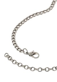 Metal kæde med sammenlänkede runde led, sølvfarvet. Har en lobster clasp og en sektion af løs kæde. Glat struktur.