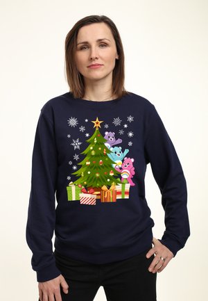 Granatowy sweatshirt z kolorową, kreskówkową grafiką przedstawiającą choinkę z ozdobami, trzy niedźwiedzie oraz prezenty pod drzewkiem.