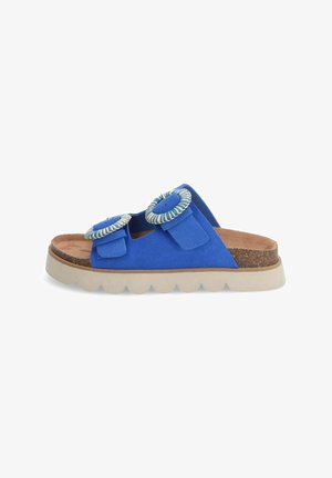 Blauwe suede slipper met twee ronde accenten, verstelbare banden en een lichtgekleurde, gestructureerde zool. Kurken voetbed voor comfort.