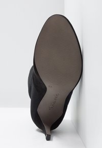 Zapato de tacón alto negro con parte superior de ante texturizado, punta afilada y suela de goma lisa con estrías, talla 37.
