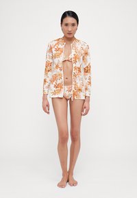 Floral-patterned swimwear set in orange and white, featuring a long-sleeve zip-up top and matching bikini bottom. Smooth fabric, fitted design.