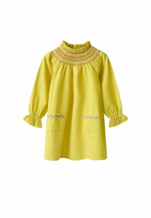 Keltainen mekko korkealla smock-kauluksella, pitkät hihat rypyttyneillä hihoilla ja kaksi etupuolella olevaa taskua, joissa on koristeommel.
