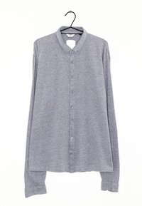Camicia grigia a maniche lunghe con bottoni realizzata in tessuto texturizzato, caratterizzata da un colletto, chiusura frontale con bottoni e polsini con bottone.