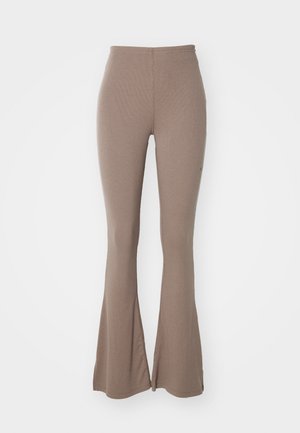 Leggings évasés marron en tissu doux et texturé. Le design présente une taille haute et une couture sur le devant de chaque jambe.