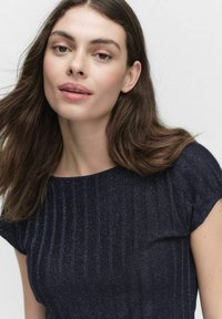 Navy blue short-sleeve top with vertical ribbed texture and subtle shimmer, featuring a round neckline and relaxed fit.